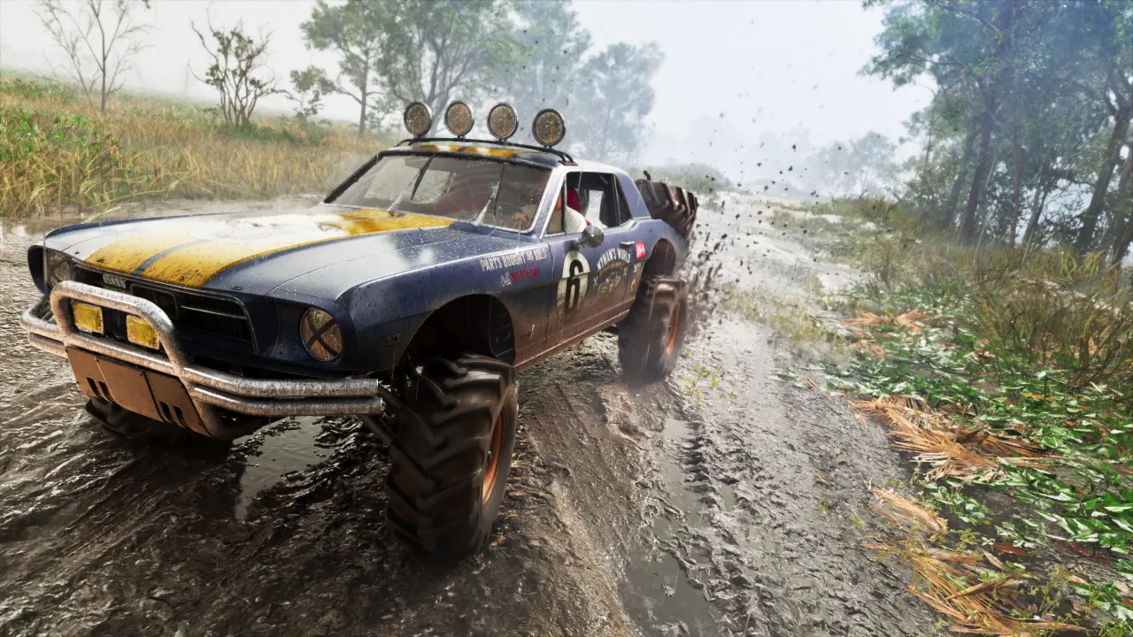 A mud-covered rally car sliding through a dirt track